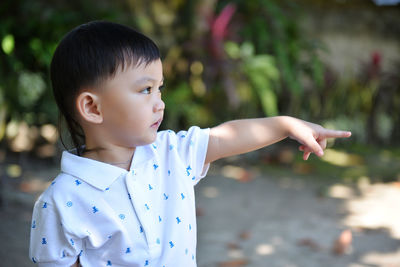 Close-up of boy gesturing while standing on field