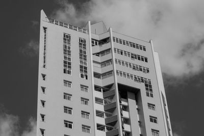 Low angle view of modern building against cloudy sky