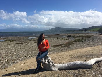 Full length of woman on beach against sky