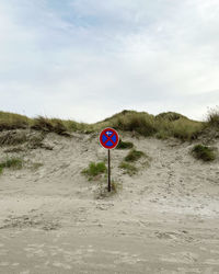 Close-up of road sign against sky