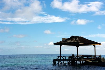 Thatched structure amidst rippled water