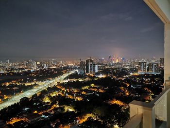High angle view of illuminated buildings against sky at night