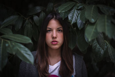 Portrait of young woman against plants