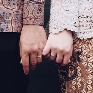 Midsection of couple wearing rings