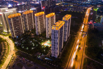 High angle view of illuminated city street and buildings at night