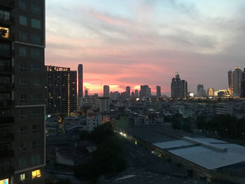 Modern buildings in city against sky during sunset