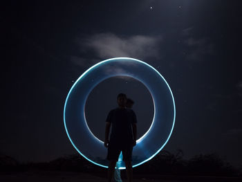 Silhouette man standing against sky at night