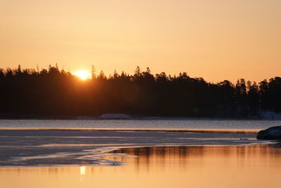 Scenic view of lake against orange sky