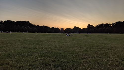 People on field against sky during sunset