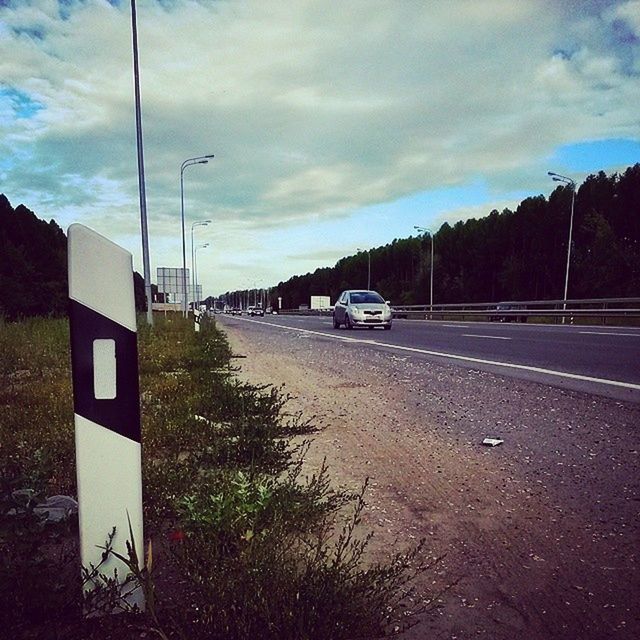 transportation, road, sky, land vehicle, car, street, mode of transport, road marking, cloud - sky, the way forward, street light, asphalt, cloud, no people, outdoors, diminishing perspective, cloudy, on the move, empty, country road