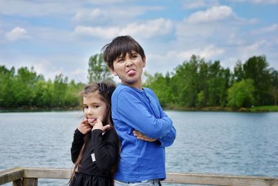 Portrait of boy with lake against sky