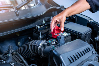 Cropped hands of man repairing car engine