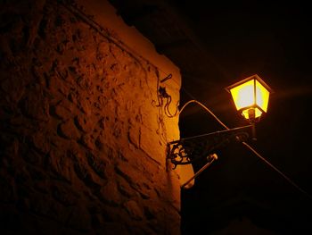 Low angle view of illuminated lamp at night