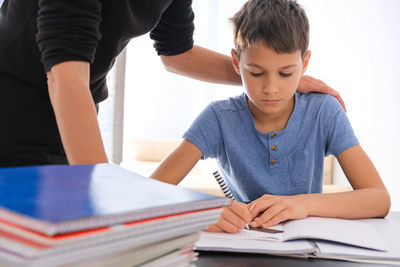 Rear view of boy sitting on table