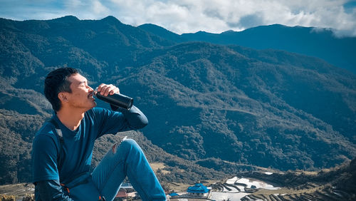 Man photographing against mountains