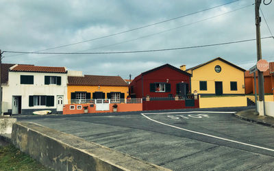 Houses by street against sky in city