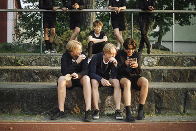 Cheerful teenage boys sharing smart phone