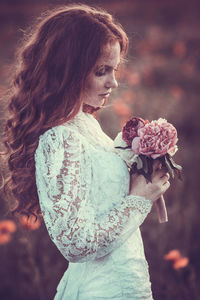 Side view of woman holding bouquet