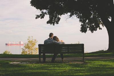 Rear view of couple sitting on bench