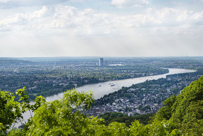 River rhein in western germany flowing along the city against the sky with clouds. visible ships.