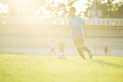 Man playing soccer ball on grass