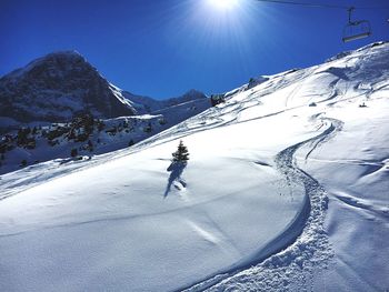 Snow covered landscape against blue sky