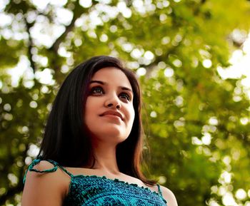 Portrait of a smiling young woman against trees