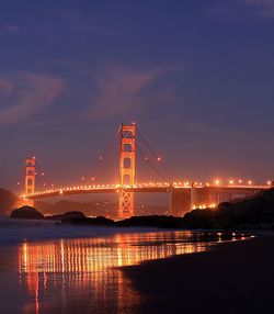 Suspension bridge over river at night