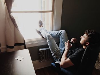 Young man looking through window