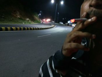 Close-up of hand on the road at night