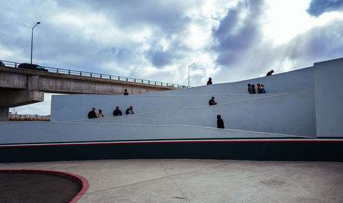 People in front of building against sky