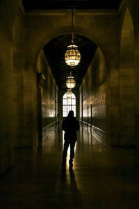 Rear view of people walking in tunnel