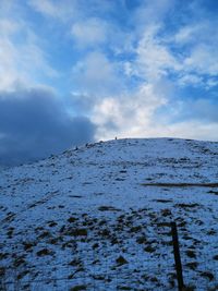 Snow covered land against sky