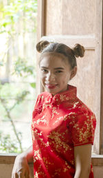 Portrait of smiling girl holding red umbrella