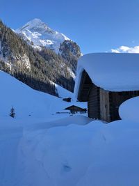 Built structure on snowcapped mountain against sky