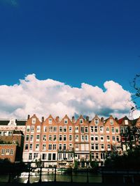 Buildings in city against blue sky