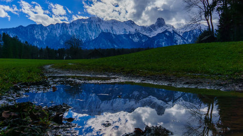 Scenic view of mountain range against cloudy sky