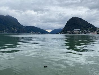 Scenic view of sea and mountains against sky