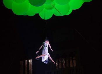 Low angle view of illuminated balloons against sky at night