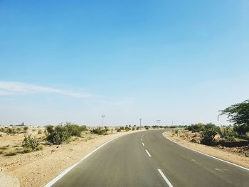 Road by trees against sky