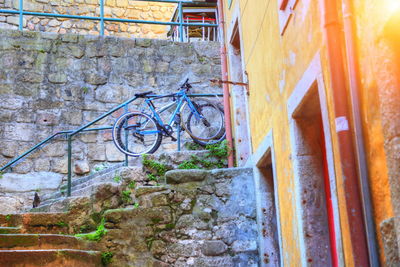 High angle view of bicycle parked on footpath by wall