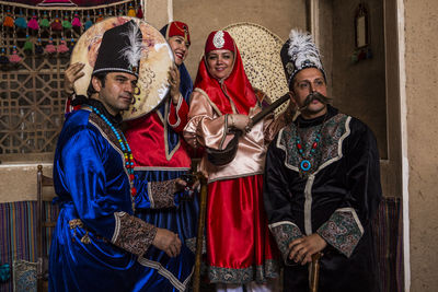 Happy family wearing traditional clothing standing with musical equipment