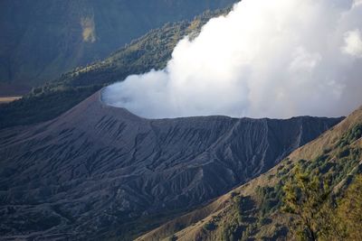 Smoke emitting from volcanic mountain against sky