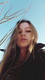 Portrait of young woman against clear sky