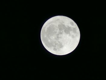 Low angle view of full moon against clear sky at night