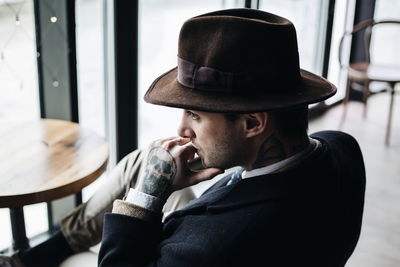 Close-up of young man sitting at cafe