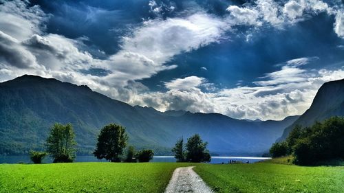 Scenic view of grassy field against cloudy sky