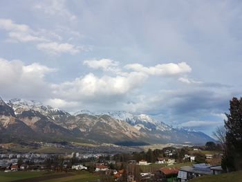 Town by mountains against sky