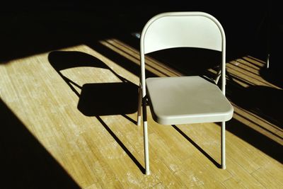 High angle view of empty foldable chair on floorboard