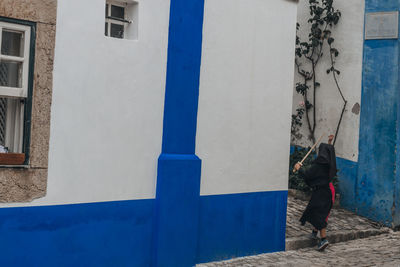 Rear view of man walking by building in city